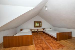 a attic room with two beds and a mirror at House Svjetlana in Postira