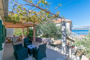 d'une terrasse avec des chaises et des tables et une vue sur l'eau. dans l'établissement House Santa Barbara, à Postira