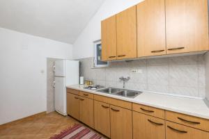 a kitchen with a sink and a white refrigerator at House Svjetlana in Postira