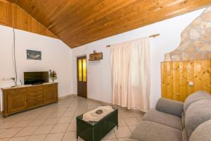un salon avec un canapé et une télévision dans l'établissement House Santa Barbara, à Postira