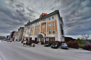 un grand bâtiment avec des voitures garées devant lui dans l'établissement Siir Boutique Hotel, à Denizli