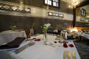 a table with utensils and a vase of flowers on it at The Repose in Salé