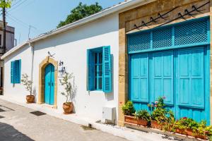 a building with blue shutters on a street at Cypriot Swallow Boutique Hotel in Lefkosa Turk