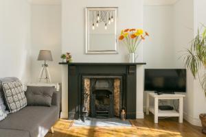 a living room with a fireplace and a television at House for Families or Groups near Cardiff City Centre in Cardiff