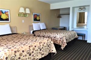 a hotel room with two beds and a window at Ramblin Rose Motel in Kingman