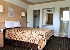 a hotel room with a bed and a bathroom at Ramblin Rose Motel in Kingman