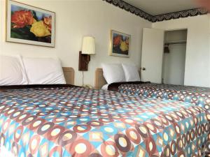 a hotel room with a large bed with a colorful bedspread at Ramblin Rose Motel in Kingman