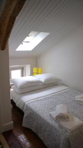 a bedroom with a large bed with two yellow glasses on it at WW Hostel & Suites in Coimbra