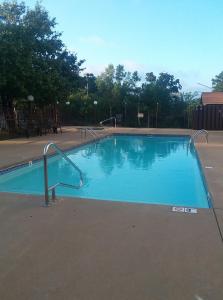 an empty swimming pool with a metal hand rail in a park at Days Inn by Wyndham Hot Springs in Hot Springs