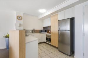 a kitchen with a refrigerator, stove, sink and microwave at Seamark on First in Mooloolaba