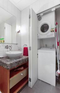 a bathroom with a sink and a washing machine at Apartment on the Beach located at The Sands in Onetangi