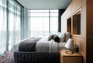 una camera da letto con un grande letto con una grande finestra di Mercure Sydney Liverpool a Liverpool