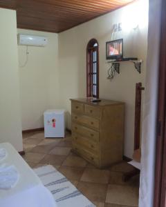 a bedroom with a dresser and a tv on the wall at Estalagem São Gonçalo in Tarituba
