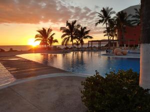 a sunset at a resort with a swimming pool at Apartamento Pelicanos, Nuevo Vallarta in Nuevo Vallarta +7 photos