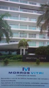 a large white building with palm trees in front of it at Cartagena Beach Condo - 1400 sq. Ft. (130 m2) in Cartagena de Indias