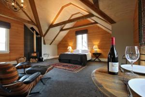 a room with a bed and a wine bottle on a table at O Naturel Vineyard Stay in Cromwell