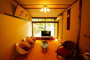 a living room with chairs and a tv and a window at Onsen Yado Mizuguchi in Izu