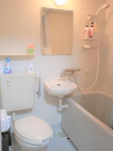 e bagno con servizi igienici, lavandino e doccia. di Yenn's Marina Inn Zamami Condominium a Zamami