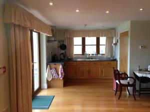 a kitchen with wooden cabinets and a table and a dining room at Orchard Manor in Probus