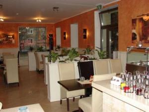 een restaurant met een bar met witte stoelen en tafels bij Hotel Galileo in Žilina