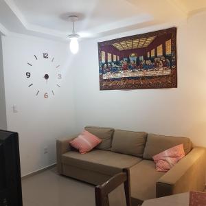 sala de estar con sofá y reloj en la pared en Edesias forte, en Florianópolis