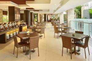 a dining room with tables and chairs in a restaurant at Primera Hotel Seminyak in Seminyak