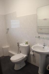 een badkamer met een wit toilet en een wastafel bij Hotel Oviya in Vavuniya
