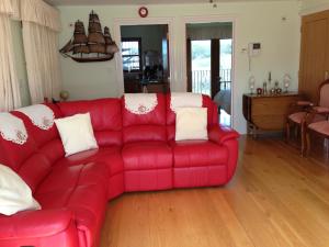 a red couch sitting in a living room at Orchard Manor in Probus
