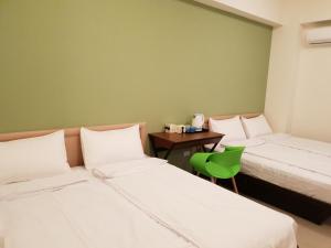 Duas camas num quarto com uma parede verde em Fun Place to Stay B&B em Weiqian