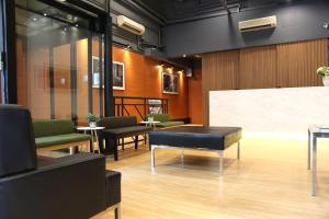 a waiting room with chairs and a table and a whiteboard at Bridal Tea House Hotel - Yaumatei in Hong Kong