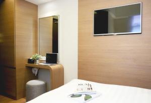 a hotel room with a bed and a television on a wall at Bridal Tea House Hotel - Yaumatei in Hong Kong +23 photos