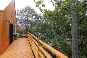 富良野的住宿－Sumika，房屋一侧的木甲板上有一棵树