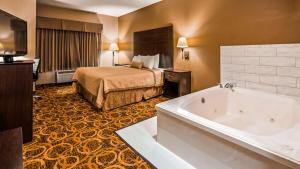 a hotel room with a bed and a tub at Best Western Northwest Inn in Dallas