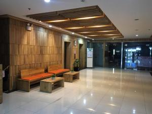 a lobby with benches and tables in a building at Simply Comfy 916 (Cityscape Bacolod) in Bacolod