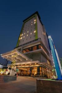 a tall building with a car parked in front of it at PrimeBiz Hotel Surabaya in Surabaya