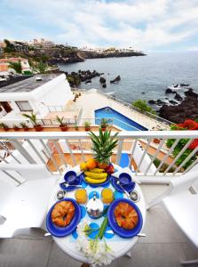 a table with food on a balcony with a view of the ocean at Punta N 5 - Vivienda vacacional in Santiago del Teide