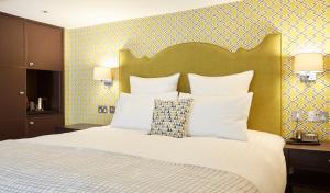 1 dormitorio con 1 cama grande con almohadas blancas en 54 Queen's Gate Hotel en Londres