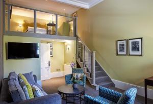Una sala de estar con un sofá y una escalera. en 54 Queen's Gate Hotel, en Londres