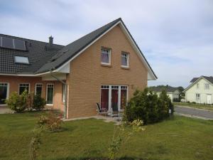 a brown brick house with a red door at Ferienwohnung Krähenberg in Grömitz