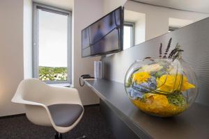 a vase filled with flowers sitting on a desk at Scala Turm Hotel Restaurant in Jena