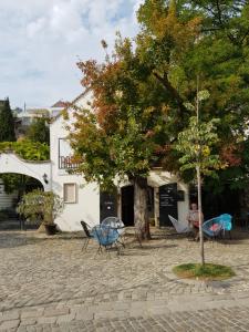 un grupo de sillas y un árbol frente a un edificio en Good Life Home Apartment Szentendre en Szentendre