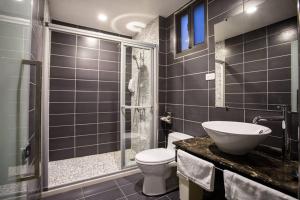 a bathroom with a toilet and a sink and a shower at Hsu One One B&B in Magong +25 photos
