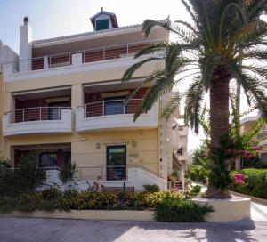 un edificio con una palmera delante de él en Poseidon Studios, en Palaiochóra