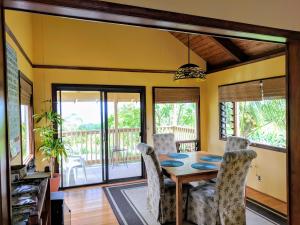 a dining room with a table and chairs at Hamakua Guesthouse in Pepeekeo