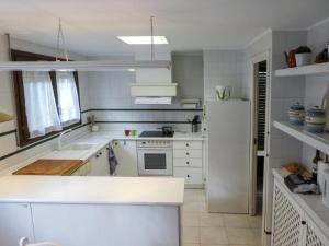 una cucina con elettrodomestici bianchi e frigorifero bianco di EL ALJEZAR a Teruel