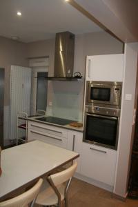 cocina con mesa y fogones horno superior en Appt Hotel republique en Lille