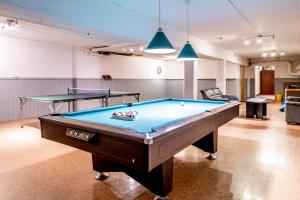 a room with a pool table and two tables at Västerbacken Hotell & Konferens in Holmsund