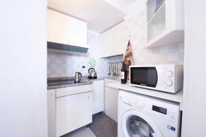 a white kitchen with a washing machine and a washer at G&G- Amalfi coast - sea view - beach in Atrani