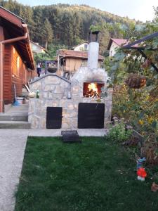 un horno de piedra con fuego en un patio en Holiday Home Veli en Sapareva Banya