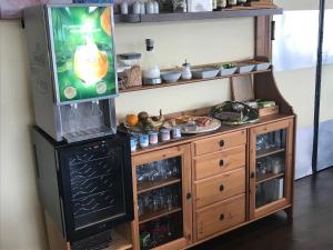 a kitchen with a tv and a wooden entertainment center at Logis Le Normandie in Caudebec-en-Caux